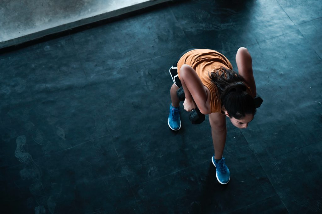 woman in orange top exercising indoors